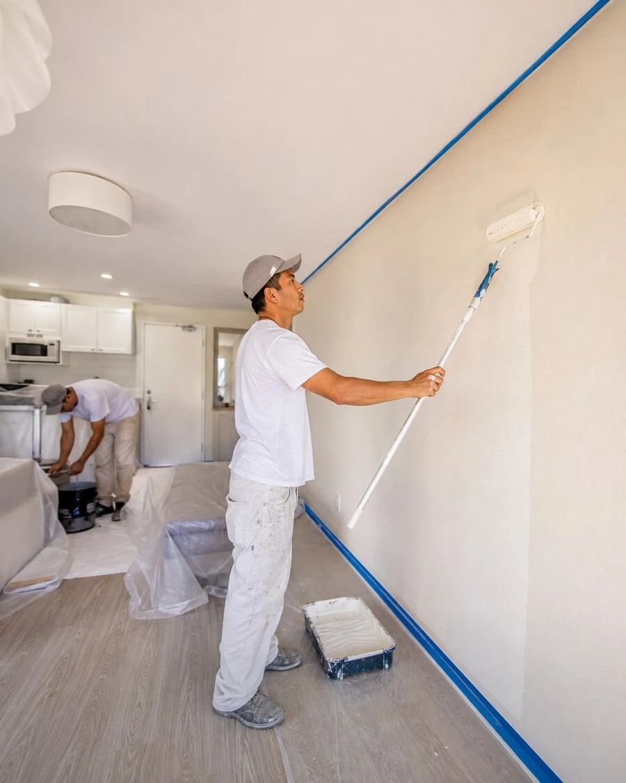 Painter completing fast wall touch-ups and a clean white repaint between guests in a Waikīkī vacation rental